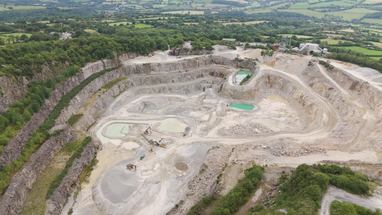 Aerial View of a Large Open-Pit Quarry with Heavy Machinery and Water Bodies