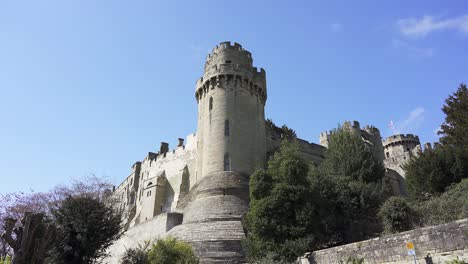 the imposing towers of warwick castle on a bright sunny spring day