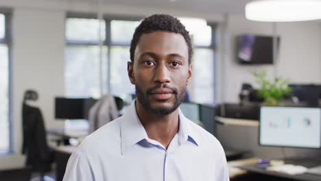 Portrait-of-happy-african-american-businessman-in-office,-slow-motion