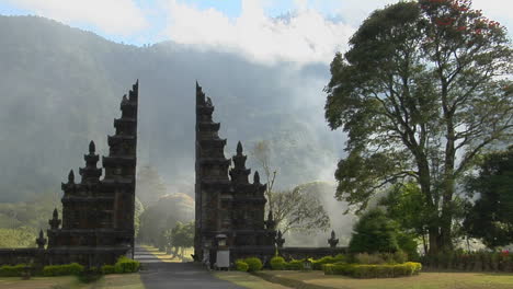 fog drifts by a traditional balinese temple gate in bali indonesia