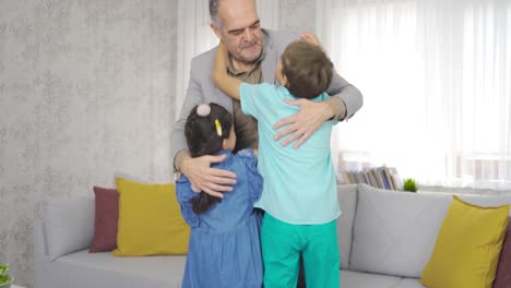 los niños visitan a sus abuelos. el abuelo abraza a sus nietos.