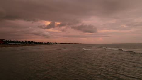 Beach-In-Canggu,-Bali-With-Surfers-At-Sunset---Drone-Shot