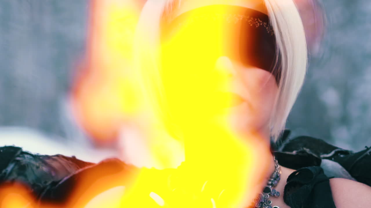 여자는 불이 난 겨울 숲에서 불사조 캐릭터를 연기한다