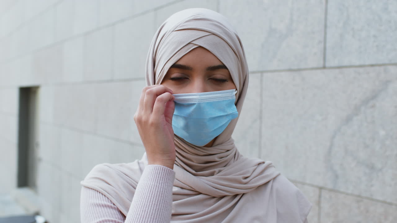 야외에서 히자브와 마스크를 입은 여성