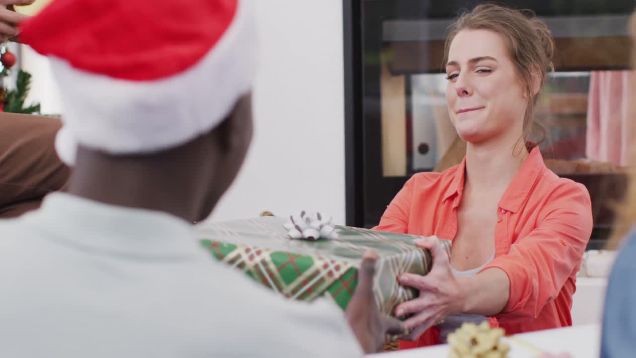 다양한 친구 들 의 행복 한 그룹 이 크리스마스 선물 을 열고 있다