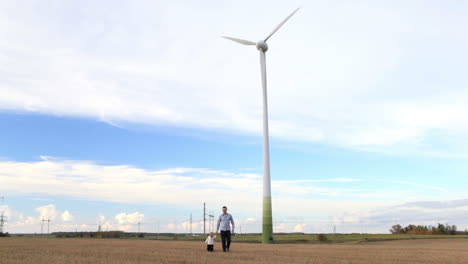 padre e hijo cerca de la turbina eólica