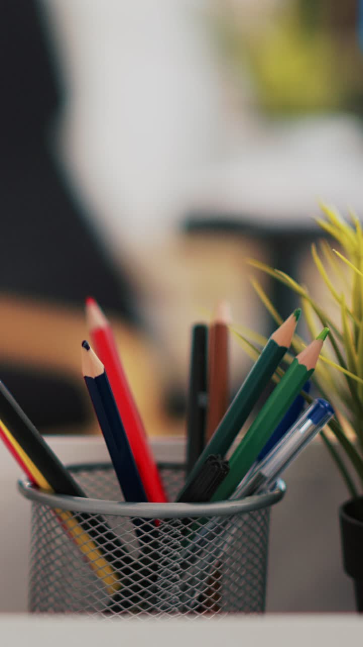 Vertical video Focus on desk belongings in modern office with laptop in background, close up