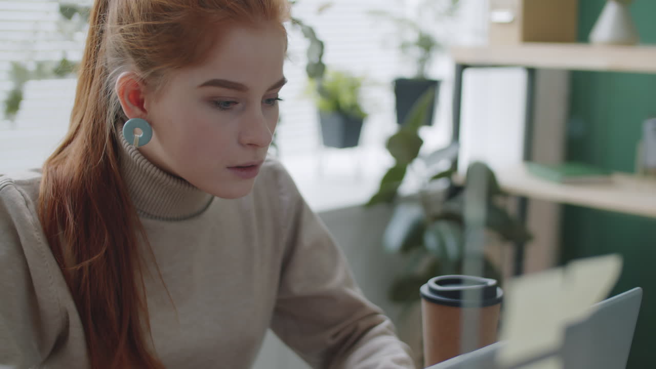 женщина, работающая за своим столом с ноутбуком и приборами для рисования и письма