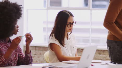 Creative-coworkers-sitting-at-a-table-in-a-meeting-room-listening-to-their-boss,-mid-section