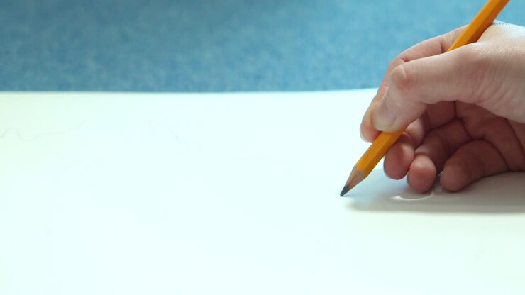 Female hand drawing with a pencil in sketchbook. Young woman learns to draw.