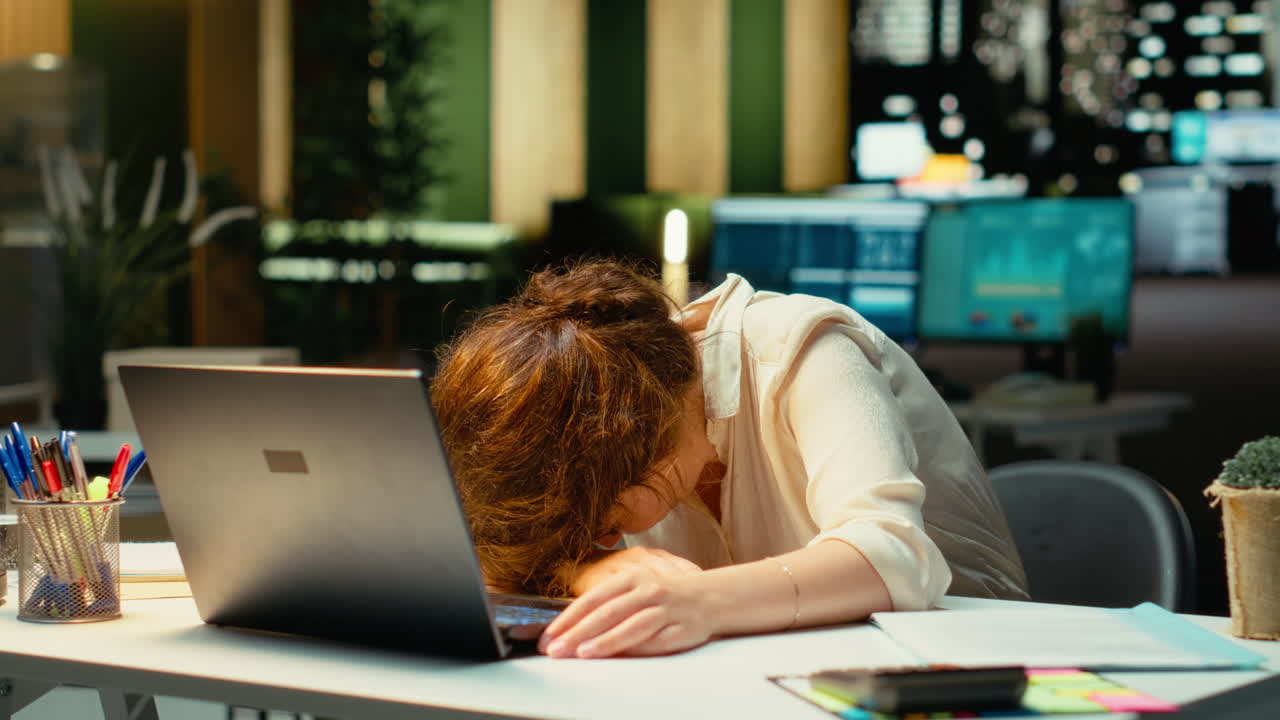 Vertical Video Business employee leaning on her desk showing symptoms of burnout syndrome