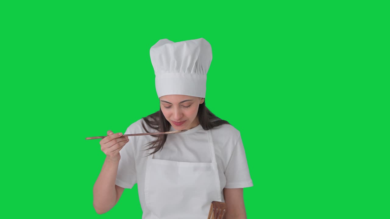 Felice chef professionista indiana che assaggia del buon cibo - schermo verde
