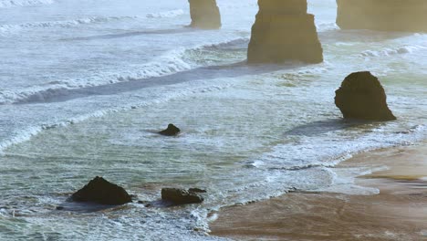 dynamic waves crash against the iconic limestone stacks of the twelve apostles, captured in serene morning light along australia's great ocean road