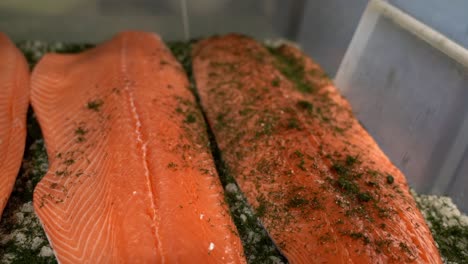 raw fish beeing marinated in spices inside small plastic box - small scale fish processing