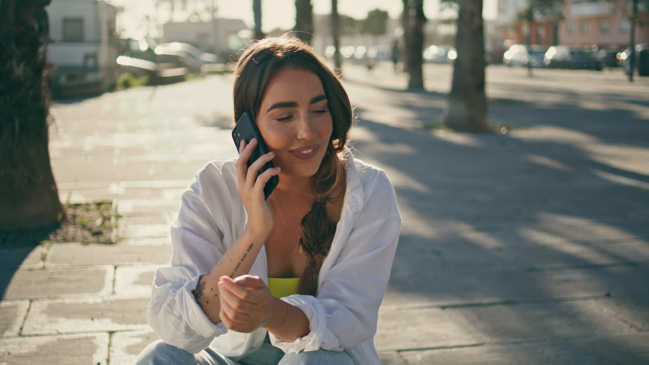 긍정적 인 소녀가 은 외관에서 전화를 걸고 있습니다. 스마트폰을 말하는 여성