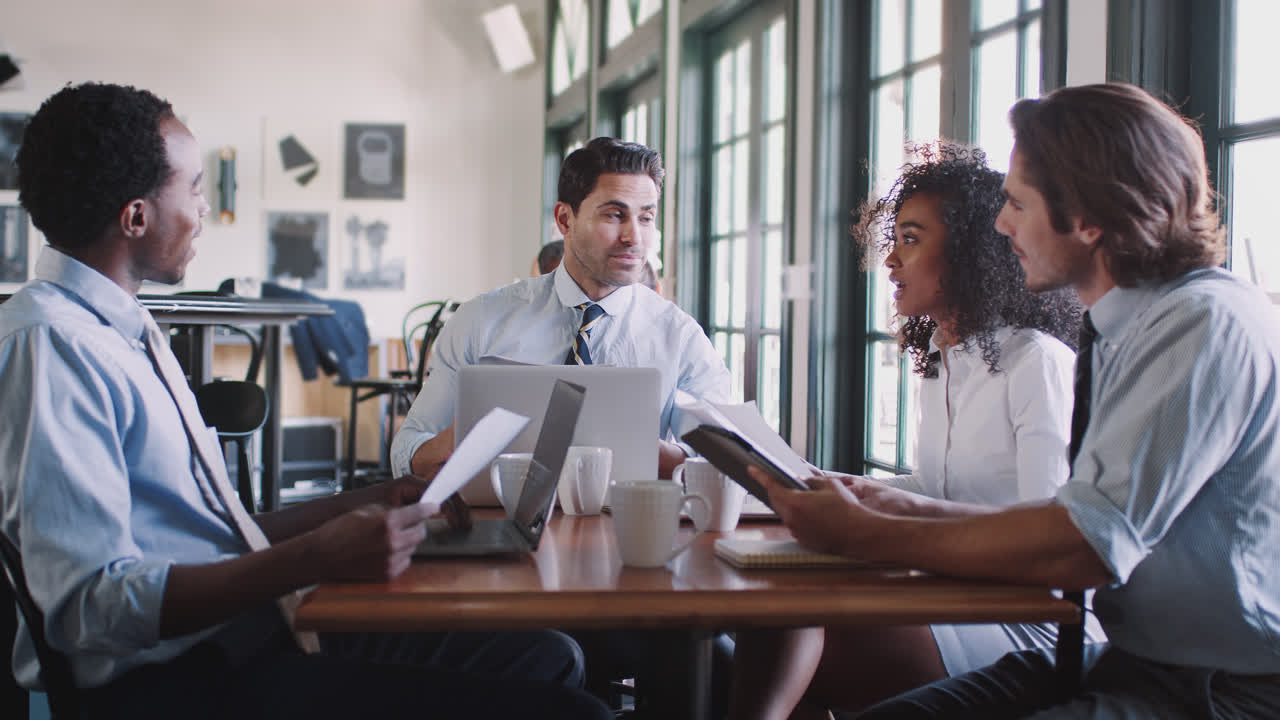 equipo de negocios teniendo una reunión informal alrededor de la mesa en una cafetería