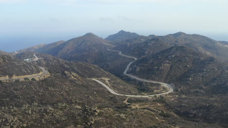 drone aerial shot of mountainous island of ios, greece, with curvy mountain road