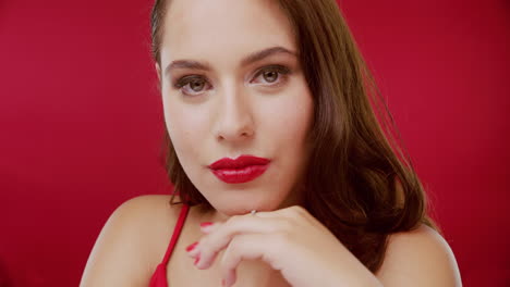 mujer con vestido rojo y lápiz labial rojo