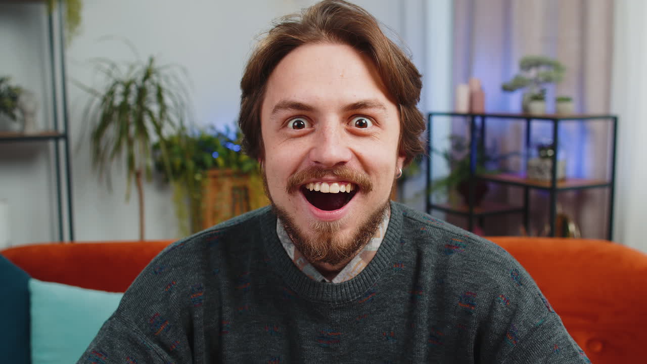 Excited caucasian man surprised shocked by sudden victory good win news celebrating wow reaction