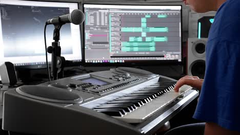 young technician sets up a keyboard for recording in a home studio