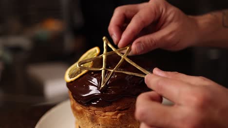 chef decorating a panettone with chocolate and a gold star