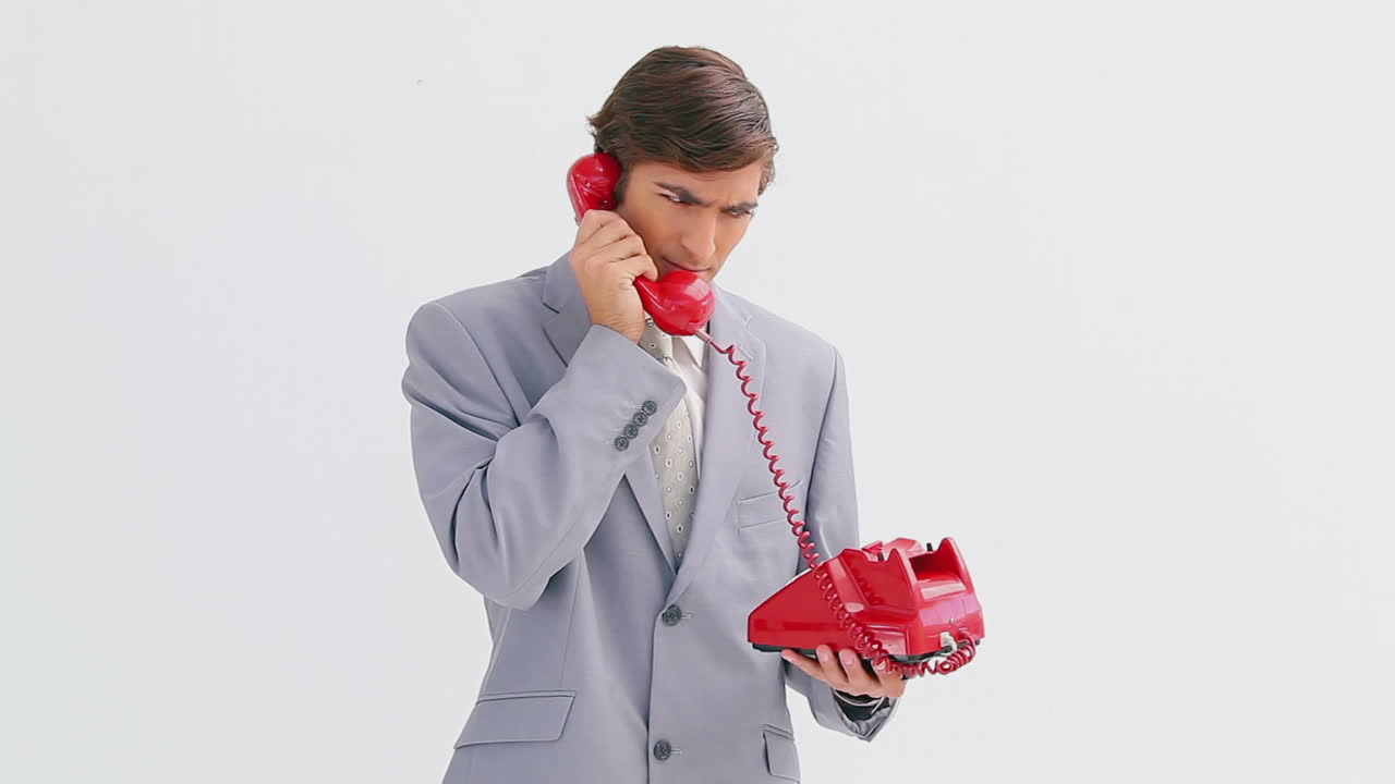 심각한 사업가가 전화로 이야기하고 있습니다.