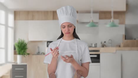 Confused-Indian-female-professional-chef-noting-down-recipe