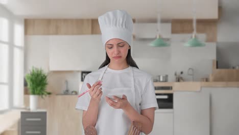 confundida mujer india chef profesional anotando la receta