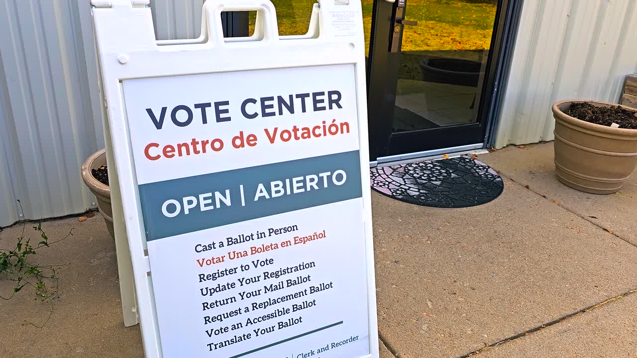 Stock video of a bilingual sign “Vote Center – Open, Abierto, Centro de Votación” with Spanish translation, capturing election inclusivity, voter registration, in-person access, mail ballot drop-offs