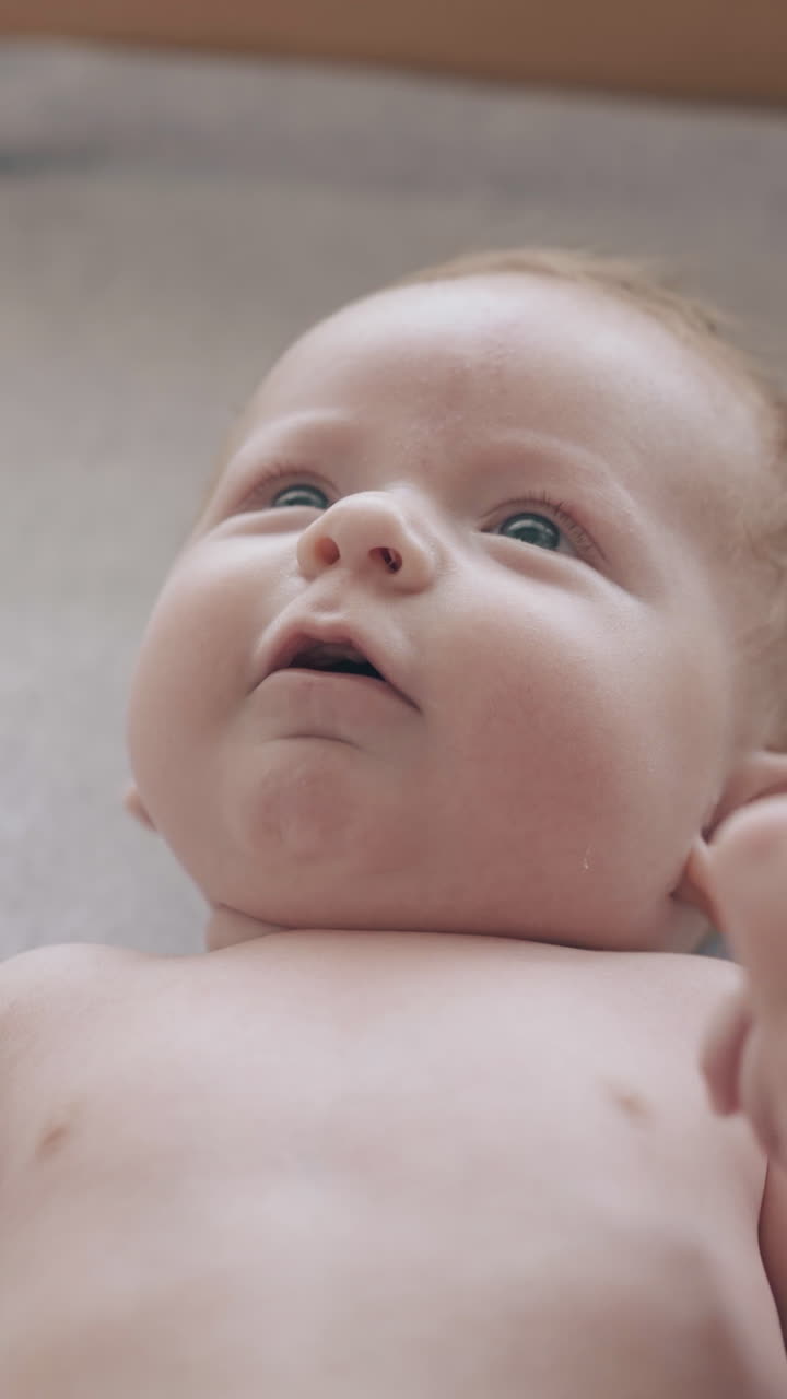 adorable little fair haired boy lies in bed professional pediatrician takes infant hands to massage close extreme view