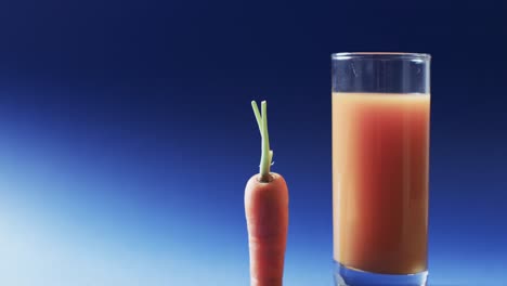 video of carrot and carrot juice with copy space on blue background