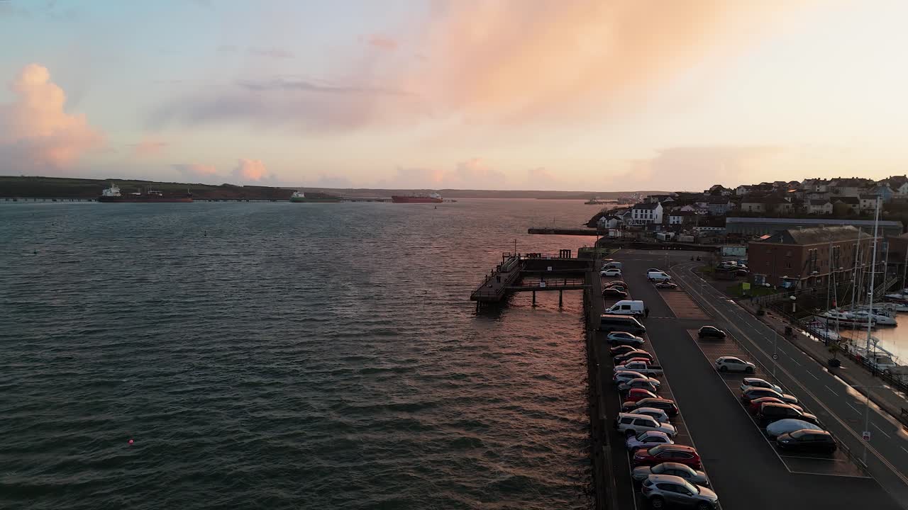 Milford waterfront, showcasing the water, boats, and nearby buildings at sunset, aerial view