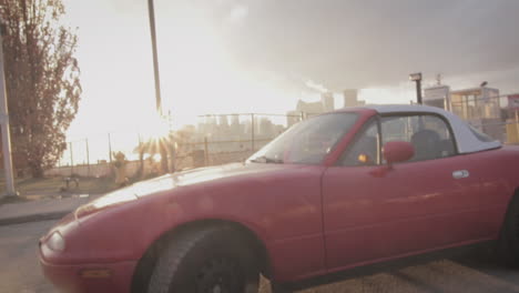 red mazda miata at sunset