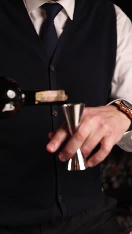 bartender pouring liquor into a jigger