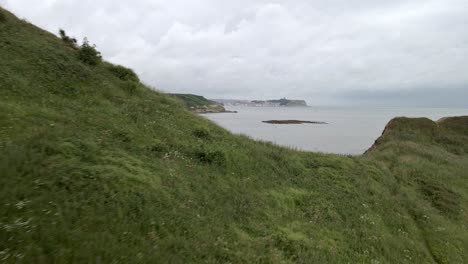 aerial reveal of a beach and scarborough town and castle, north yorkshire