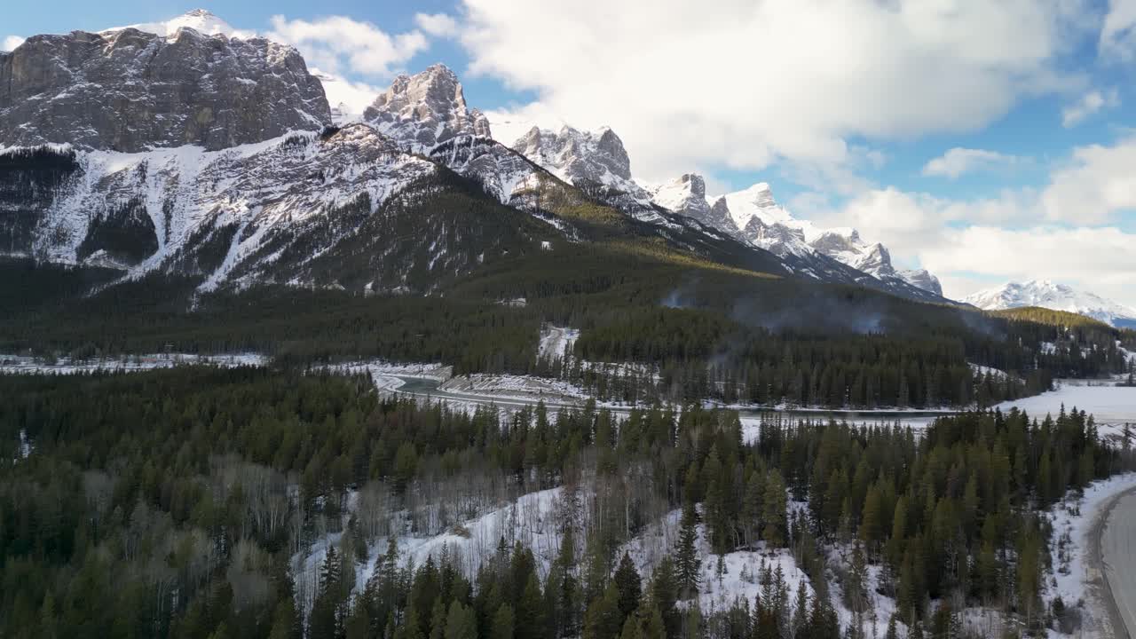vista aérea de un bosque con humo de fuego y montañas, canmore, alberta, canadá