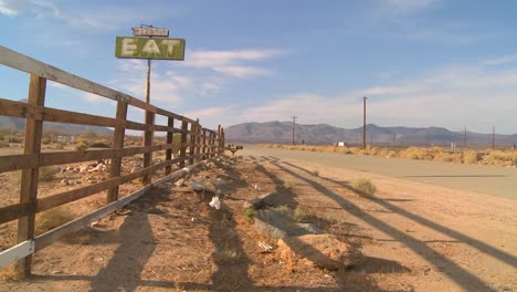 Shadows-fall-around-an-abandoned-diner-with-a-sign-reading-eat