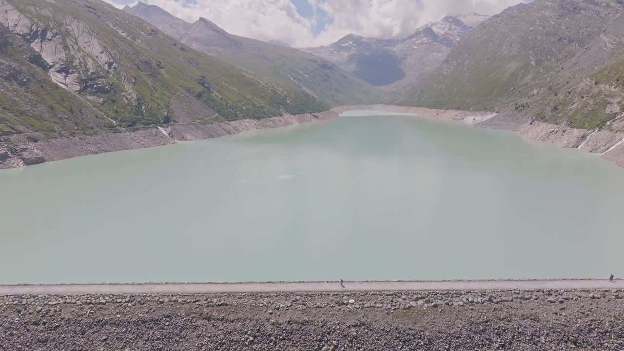 Two hikers explore Saas-Fee, Saas-Balen, and the Saas-Almagell dam, passing waterfalls, marmots, and alpine peaks in a breathtaking high-mountain landscape.
