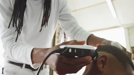 hombre africano cortando el cabello de un niño africano