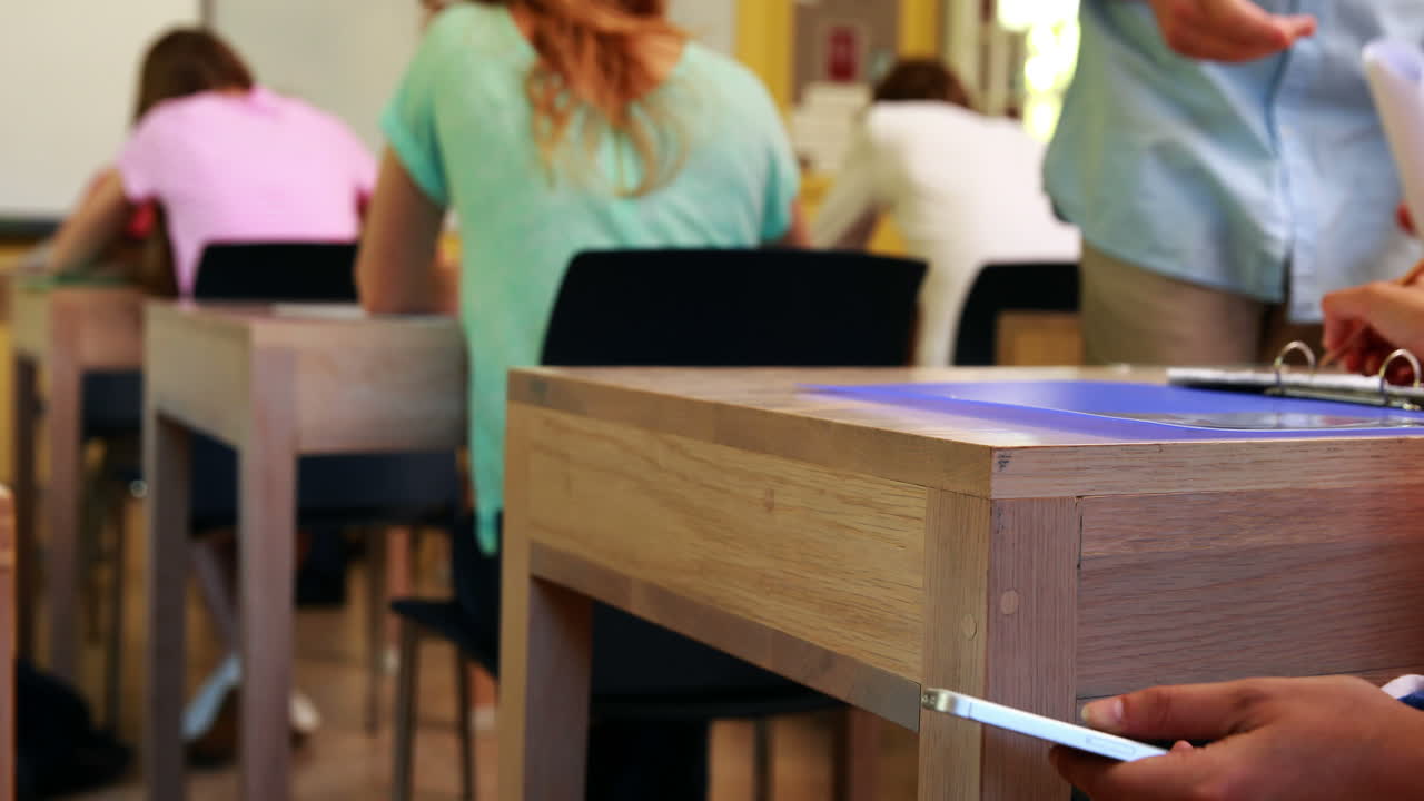 el teléfono del estudiante es confiscado por el maestro.