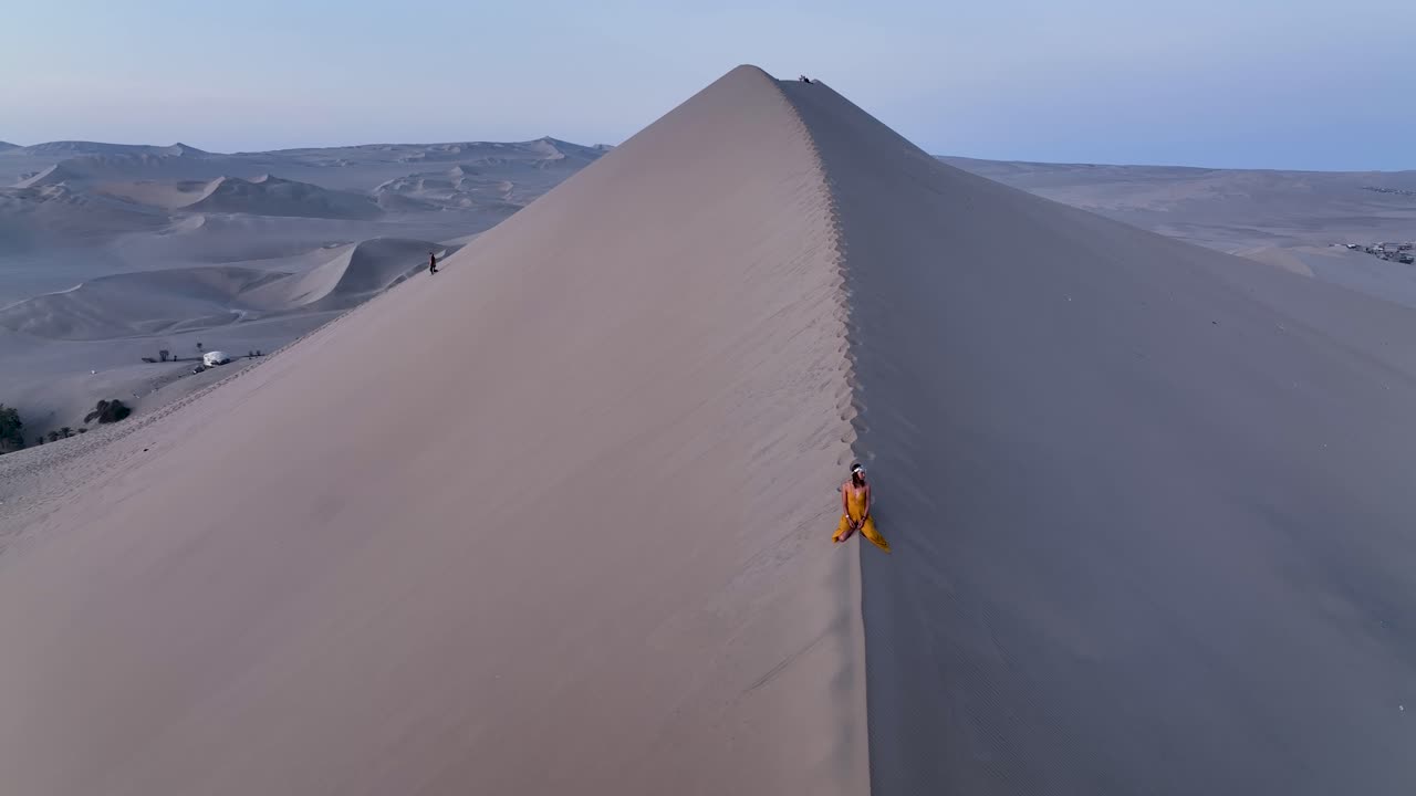 mujer caminando por una duna de arena