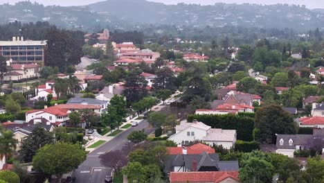 Establishing-aerial-view-rising-above-Westwood-neighbourhood,-Los-Angeles-residential-district-misty-suburban-rooftops