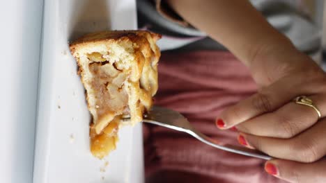 mujer comiendo una rebanada de pastel de manzana