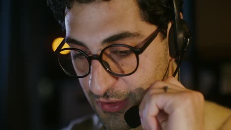 primer plano de un hombre trabajando desde casa, usando auriculares y gafas