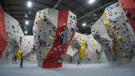indoor rock climbing adventures: athletes scaling diverse boulder routes in a vibrant climbing gym environment focused on skill, technique, and team spirit