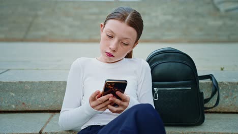 teenage girl using smartphone on stairs