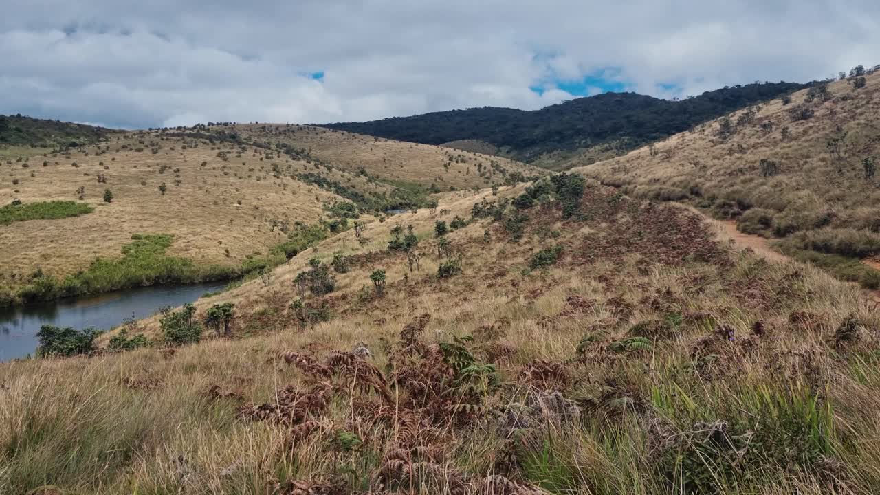 Vista panorámica de Horton Plains, Sri Lanka, con praderas abiertas y terrenos escarpados que se extienden entre la niebla bajo un cielo gris y nublado
