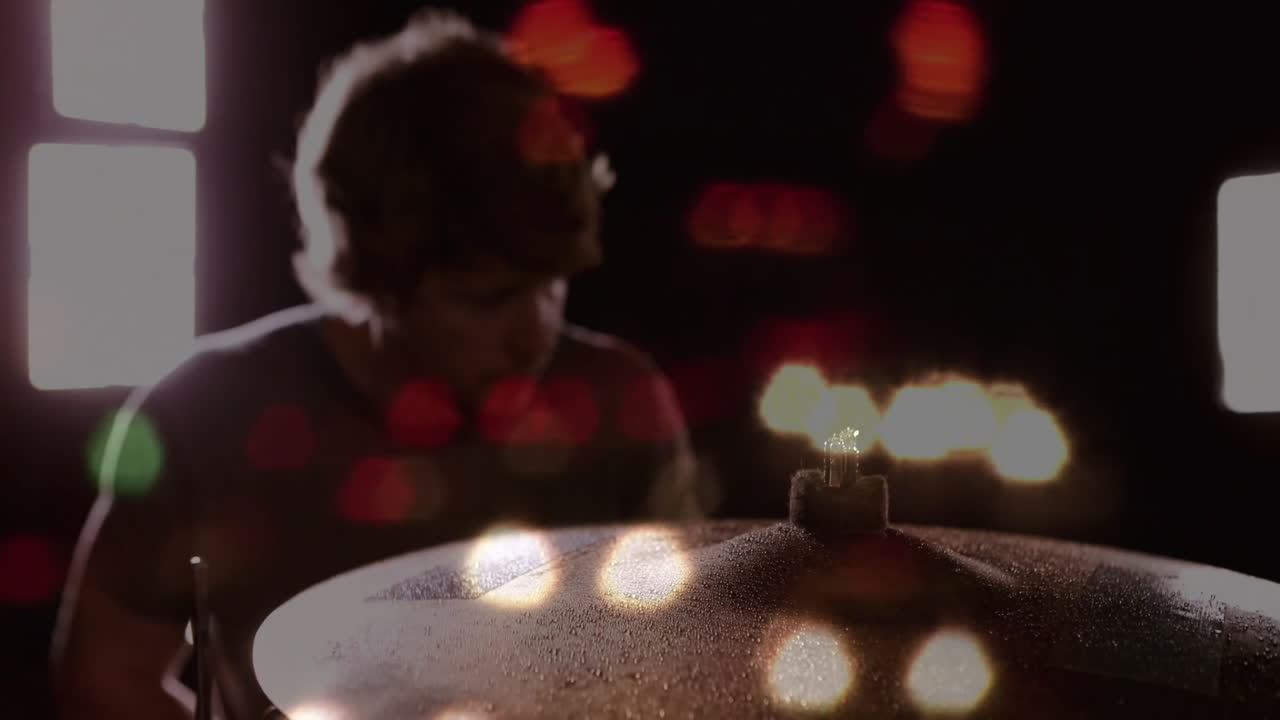 Drummer playing drum kit in music studio, displaying animated soundwaves over cymbal droplets