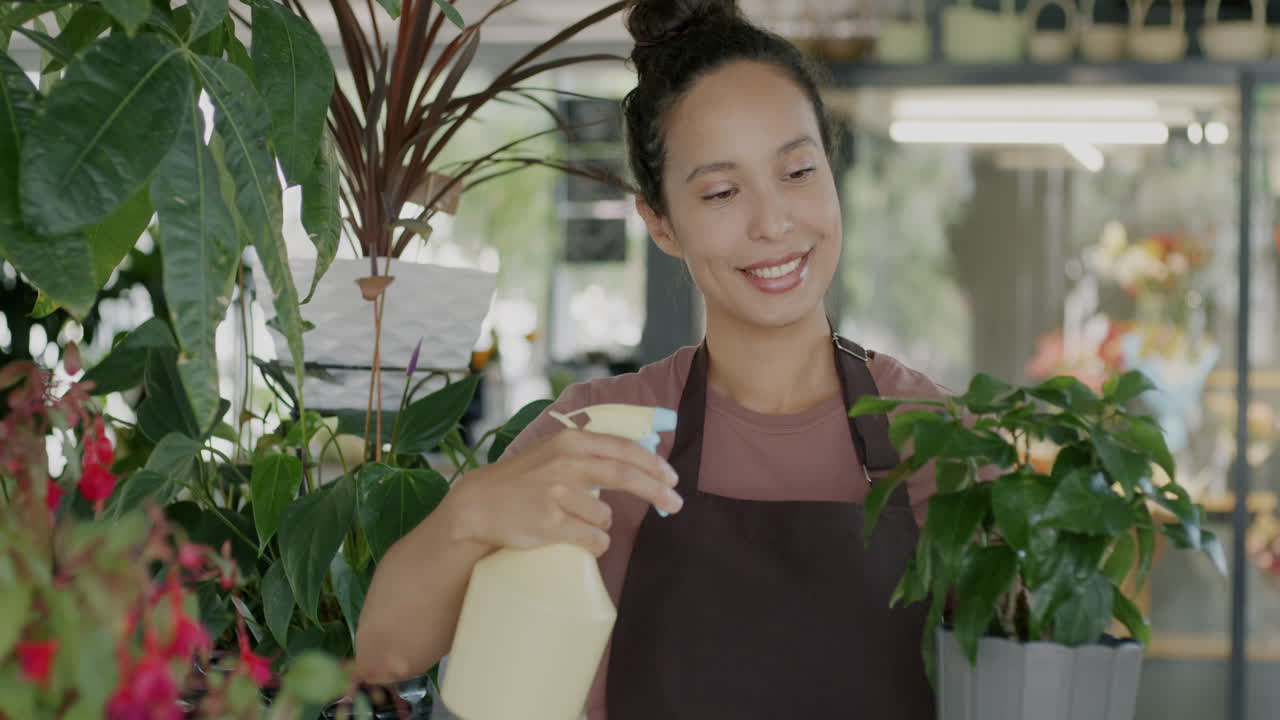 꽃 가게 에서 식물 에 물 을 주고 있는 여자