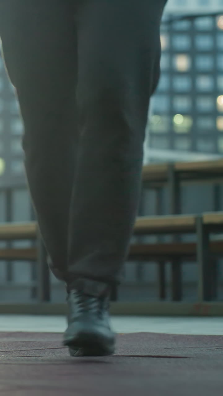 vista de la pierna de un atleta hábilmente haciendo malabarismos con el fútbol en la arena deportiva, destacando el control preciso de la pelota, la concentración y la destreza atlética contra un telón de fondo urbano con bancos y caminos iluminados